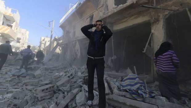 A man reacts at a site hit by what activists said were explosive barrels thrown by forces loyal to Syria's President Bashar al-Assad in Aleppo.