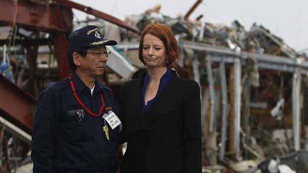 Julia Gillard is escorted by mayor Jin Sato as she visits the town of Minamisanriku, devastated by the March 11 earthquake and tsunami.