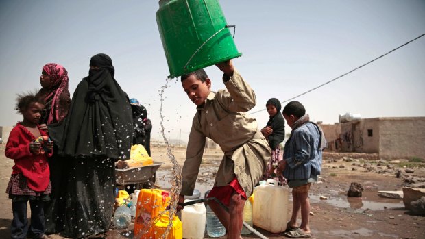 A boy rinses a bucket as he and others collect water from a well that is allegedly contaminated with cholera bacteria, on the outskirts of Sanaa, Yemen.