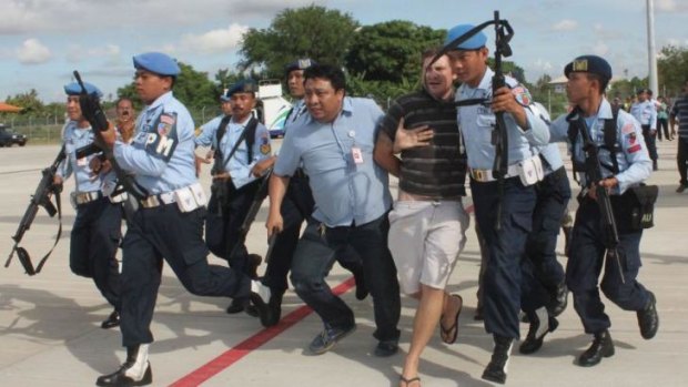 Indonesian military officers haul Matt Christopher Lockley away.