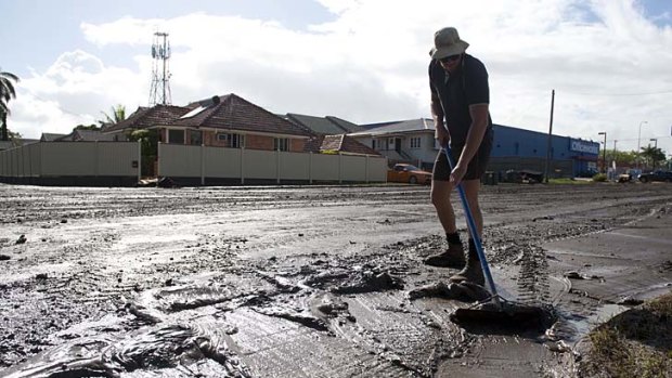 A man cleans up mud days after flooding in Bundaberg.