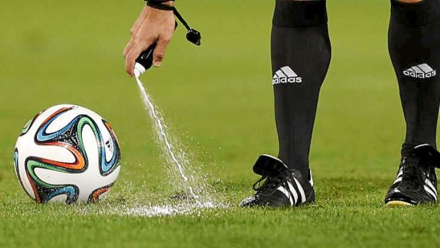 Referee Carlos Velasco of Spain marks a line with a spray at the Club World Cup.