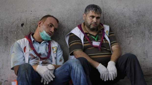 Exhausted Palestinian medics take a break after carrying wounded people injured from the Israeli strike in the Shujaiyah neighbourhood, into the emergency room at Gaza City's Shifa Hospital.
