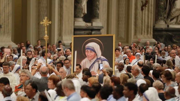 A portrait of Mother Teresa is carried in the crowd during a vigil of prayer in preparation for her canonization in St. John in Latheran Basilica, Rome. 