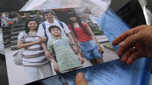 Tragic loss ... A relative shows a photo of four members of a family who were passengers of AirAsia Flight 8501, at the crisis centre at Juanda International Airport in Surabaya, East Java, Indonesia.