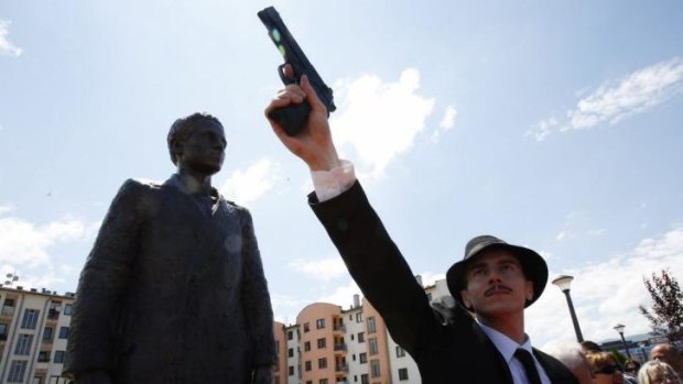 Posing: Bosnian actor Jovan Mojisilovic with a plastic replica gun during the  unveiling of the statue of Gavrilo Princip in Istocno Sarajevo.