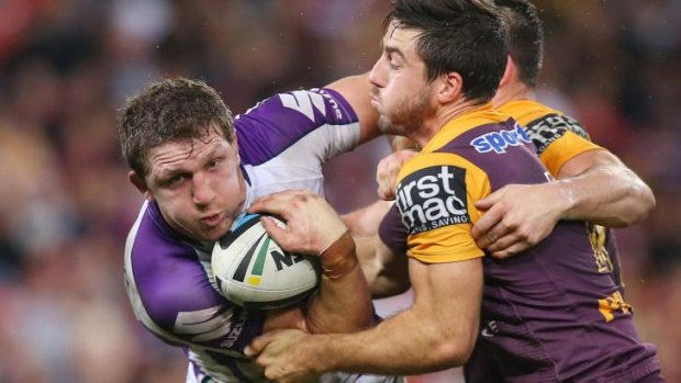 Ryan Hoffman of the Storm is tackled by Matt Gillett and Ben Hunt of the Broncos.