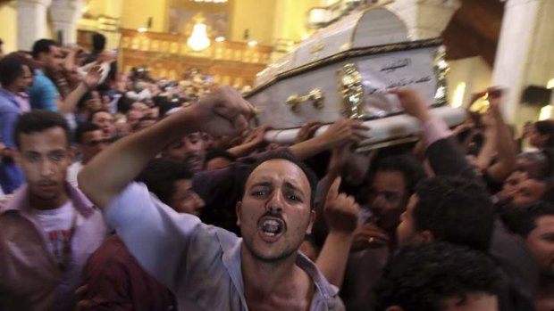 Angry confrontation: Coptic Christians carry the coffins of men who died during clashes between Muslims and Christians outside Cairo.