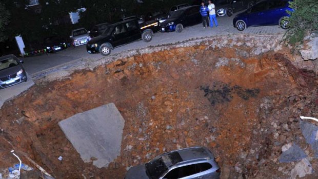A car sits in a huge hole after a cave-in   in Guiyang, China.