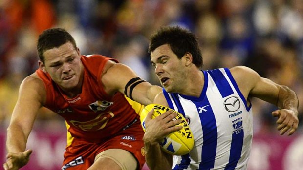 On the move: North Melbourne's Patrick McCarthy baulks to evade the clutches of Suns defender Steven May.