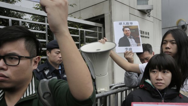 A protester holds a photo of missing bookseller Lee Bo during a protest in Hong Kong.