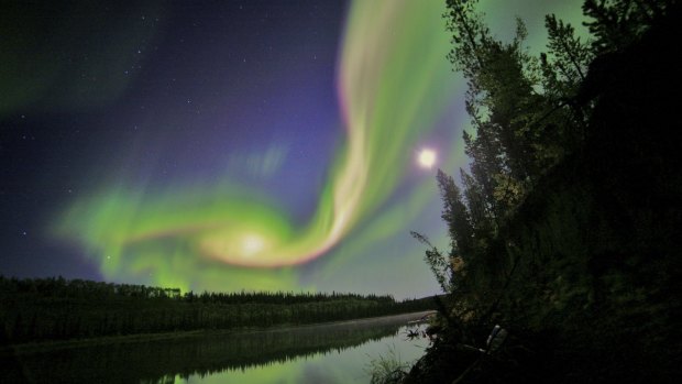 Swirls of green and red appear in an aurora over Whitehorse, Yukon.