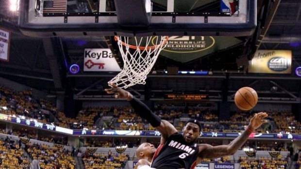 Miami's LeBron James goes to the basket despite the heavy defence of Indiana Pacers forward David West.