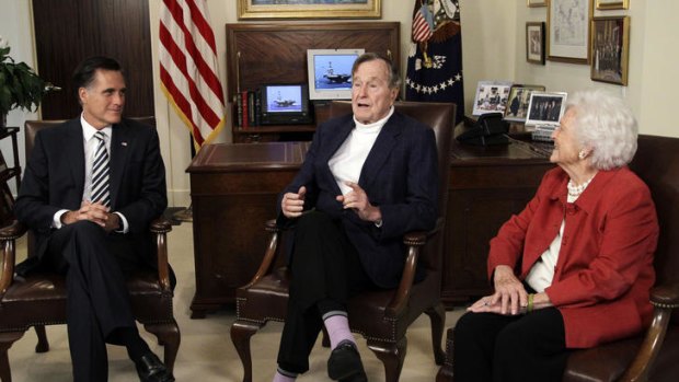 George Bush snr alongside his wife, Barbara, and Mitt Romney in Mr Bush's Houston office.