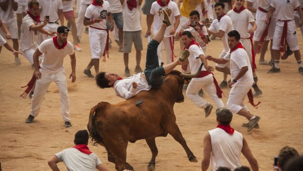 A reveller is thrown by a bull at the San Fermin Festival, in Pamplona.