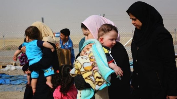 Families fleeing the violence in the Iraqi city of Mosul arrive at a checkpoint on the outskirts of Erbil.