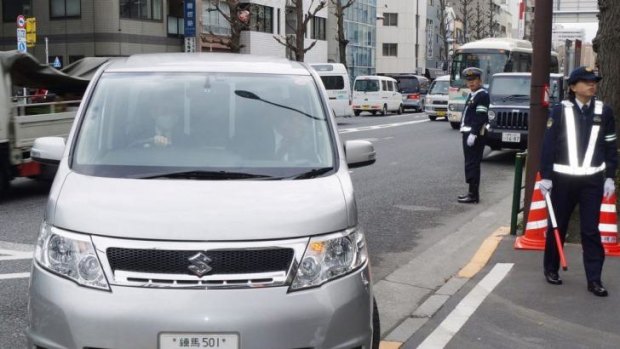 A police vehicle transports a man who was arrested for vandalising copies of Anne Frank's <i>The Diary of a Young Girl</i> in Tokyo libraries.