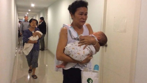 Baby factory? Nannies cradle surrogate babies during a raid in Bangkok.