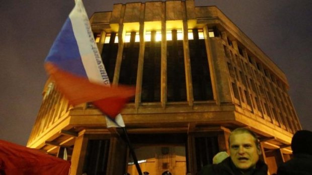 A man waves a Russian flag in front of a local parliament building during a pro-Russian rally in Simferopol, Crimea. 