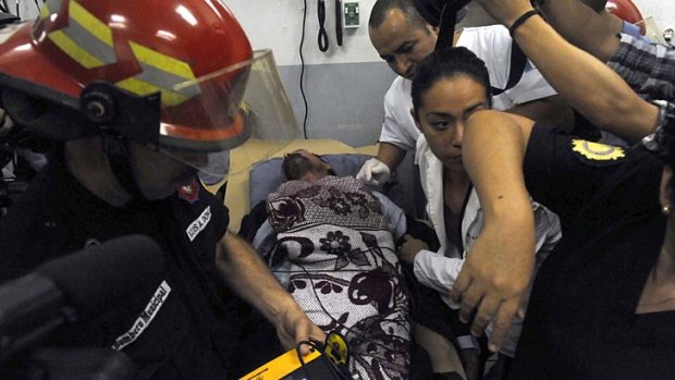 John McAfee is attended to by doctors and nurses at the national Police Hospital in Guatemala City.