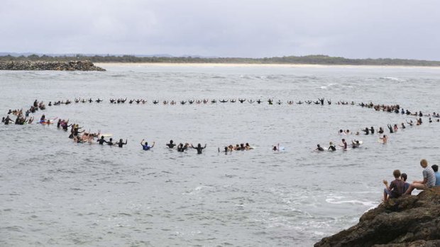 Vale Zac Young: Friends of the teenage shark attack victim form a circle off Port Macquarie's Town Beach to remember him.