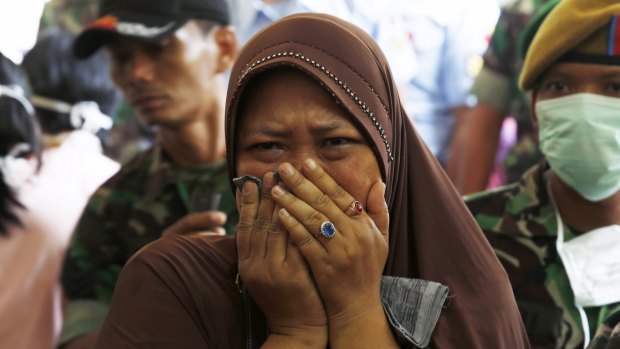 A mother, whose son was a victim of the Indonesian Air Force C-130B Hercules crash, cries outside Adam Malik hospital in Medan, Indonesia.