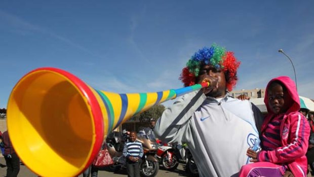 A South African soccer fan blows a plastic trumpet known as a vuvuzela.