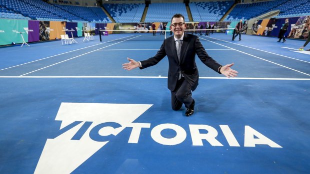 Premier Daniel Andrews poses with the new logo for Victoria.