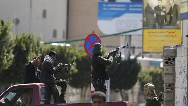 A Houthi fighter fires at forces guarding the Presidential Palace.
