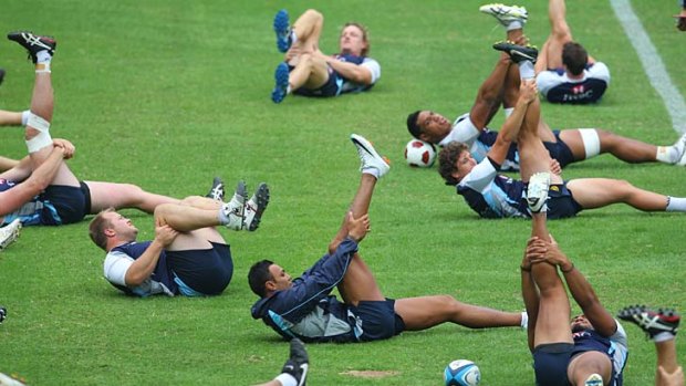 Bring on the stretchers . . . Waratahs players train at the SFS yesterday.