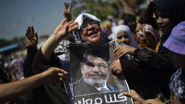 Warned: Members of the Muslim Brotherhood and supporters of Mohammed Mursi (portrait) take part in the sit-in.