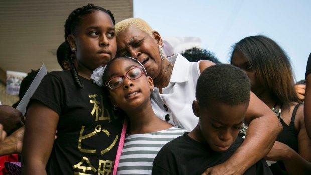 Grieving: Diann Aldridge hugs her grandchildren, Summer, left, 12, Sincere, right, 10, and Shavae, centre, 8, during a vigil for their mother, Nykea Aldridge, at the Willie Mae Morris Empowerment Center on Sunday afternoon in Chicago. 