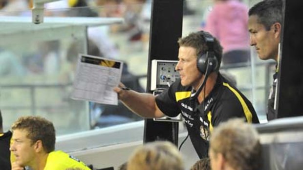 Damien Hardwick speaks to his coaching staff from his dug-out at the MCG.