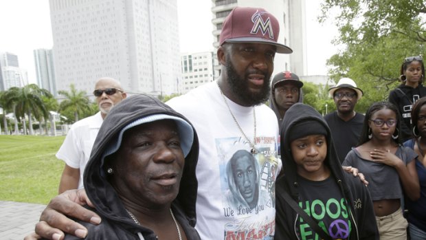 Tracy Martin, centre, father of Trayvon Martin, poses for photos with supporters wearing hoodies at a 'Justice for Trayvon' rally on Saturday, July 20, in Miami.