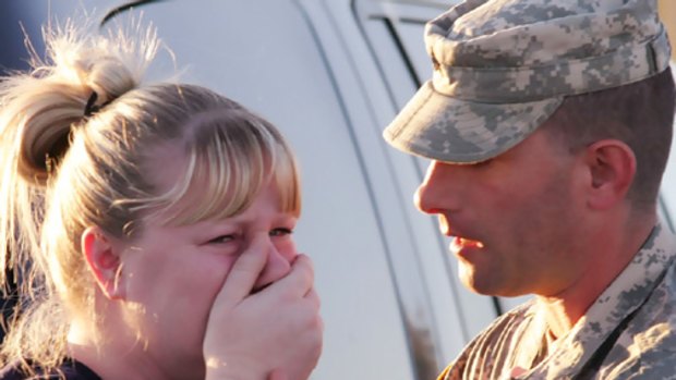 Sgt Anthony Sills comforts his wife as they wait outside the Fort Hood army base.