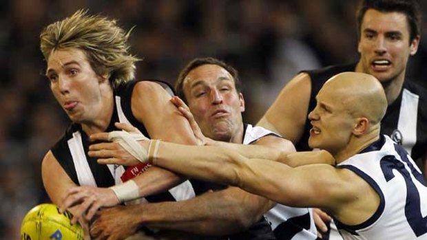Magpie Dale Thomas tries to break free of a pursuing Brad Ottens and Gary Ablett last night.