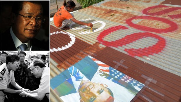 Cry for help? ... a girl paints "SOS" under a portrait of the visiting US President. Top left: Hun Sen this year, and below, with dissident Khmer Rouge leader Ieng Sary in 1996.