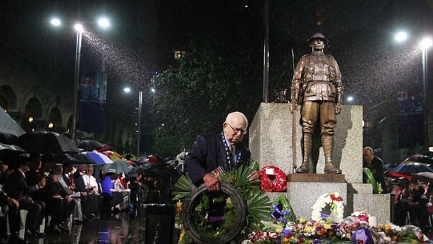 Wal Scott-Smith, Chief Cenotaph Attendant, endures the heavy rain at the  Anzac Day dawn service at the Martin Place Cenotaph in Sydney.