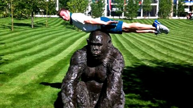 Matthew Mitcham planks on a statue after his arrival at the Olympic village.