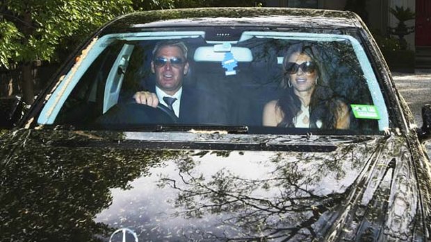 Hounded by paparazzi ... Shane Warne and Liz Hurley leave his Brighton home on Thursday.