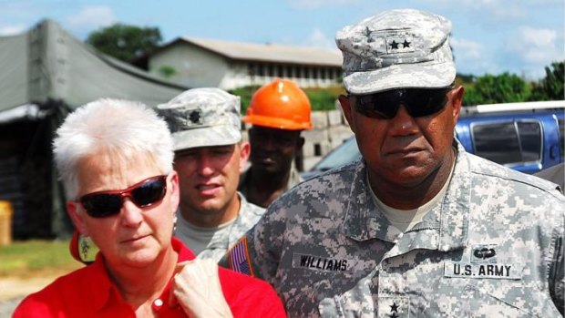 Deborah Malac, US Ambassador to Liberia, and Major General Darryl A. Williams, commanding general of US Army Africa, listen to a briefing from an Ebola treatment unit in Tubmanburg, Liberia. 