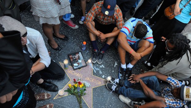 Fans of  Michael Jackson sit around the singer's star on the Hollywood Walk of Fame in Los Angeles.