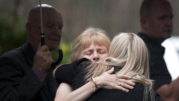 Moment to comfort &#8230; mourners embrace at the funeral service of Matt Golinski's wife and three young daughters.
