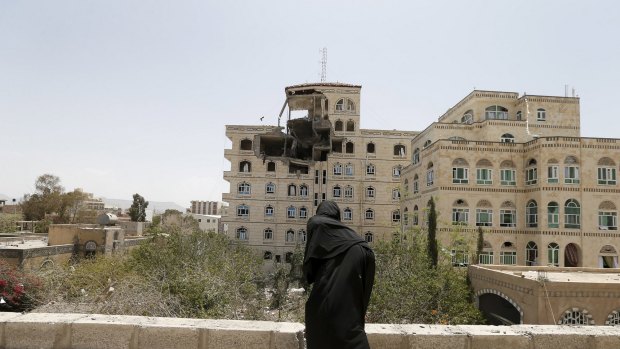 A girl looks from the roof of her house, which is located next to the building of the Houthi movement's politburo that was hit by a Saudi-led air strike on Tuesday.