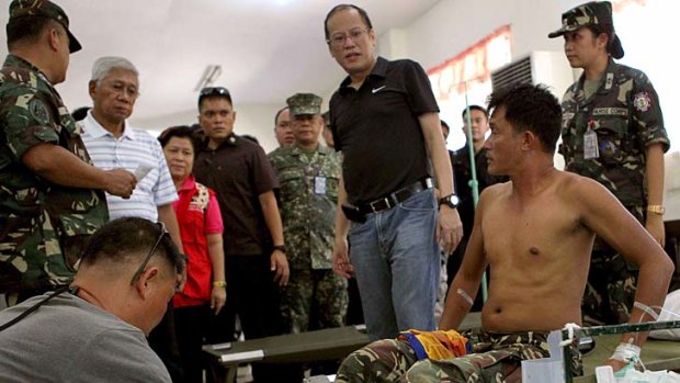 President Benigno Aquino checks on the condition of wounded soldiers at the Camp Navarro Hospital in Zamboanga City in the southern Philippines.
