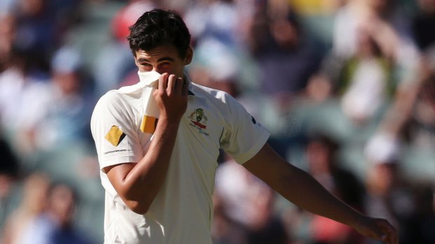 Mitchell Starc covers his face after a missed catching chance off his bowling against South Africa during the test match in Adelaide on November 26.