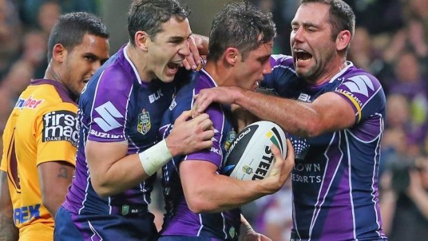 Big guns fire: Billy Slater and Cameron Smith celebrate with Cooper Cronk after the Storm halfback went over for their second try.