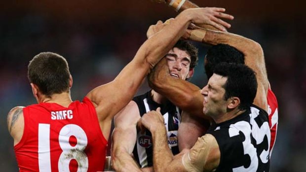 Collingwood and Sydney Swans players find themselves in a tangle of arms and bodies at ANZ Stadium last night.