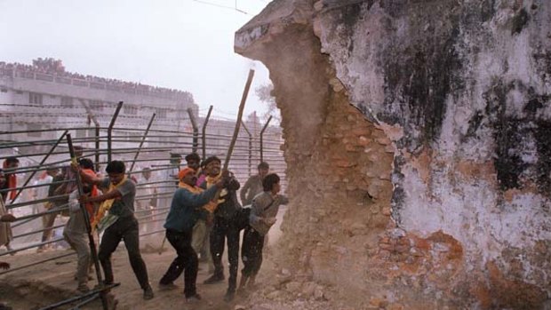 This file photo from December 1992 shows Hindu fundamentalists attack the wall of the 16th century Babri Masjid Mosque with iron rods at a disputed holy site in the city of Ayodhya.