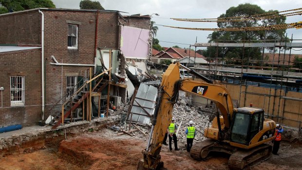 An excavator demolishes the building, which was structurally unsafe.